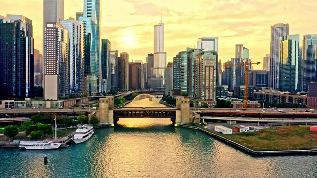 Revealing shot of Chicago, Illinois skyline at sunset with slow camera uptilt above Chicago River. Chicago is the most populous city in the U.S. state of Illinois and in the Midwestern United States