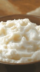 Creamy mashed potatoes in bowl on wooden table