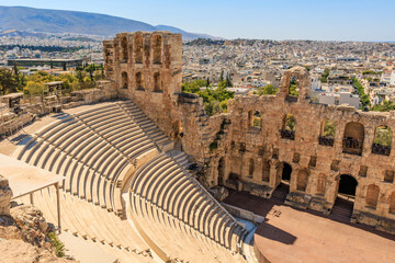 A large, empty amphitheater with a view of a city in the background, the Acropolis of Athens