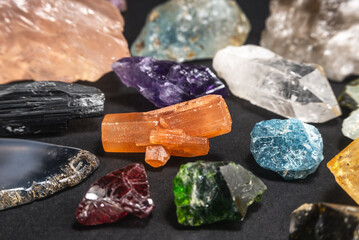 Collection of various stones and geological minerals on dark background. Close-up of various uncut and raw mineral stones and gemstones