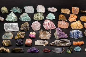 Collection set of various stones and geological minerals on dark background. Colorful, various raw mineral stones and gemstones