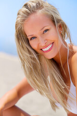 Naklejka premium Woman, portrait and outdoor beach breeze, travel and island for ocean holiday or summer vacation. Happy female person, wind and smile for weekend trip on sand, relax and confidence in outdoor nature