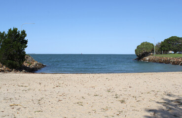 View of the beach, ocean, sand and trees at Spinnaker Park in Gladstone, Queensland, Australia