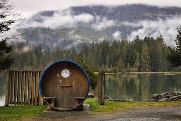 Misty mountain lake with cabins. Lush forest surrounds tranquil water, vancouver island, british colombia, canada