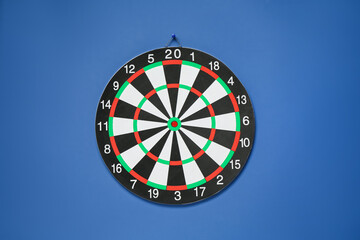 One dart board hanging on blue wall
