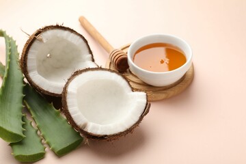 Hair treatment. Fresh coconut, honey and aloe leaves on beige background, closeup. Space for text