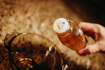 Olive oil pouring from a glass bottle – healthy fats for cooking, keto diet and Mediterranean...