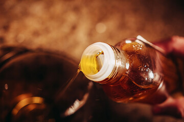 Olive oil pouring from a glass bottle – healthy fats for cooking, keto diet and Mediterranean...