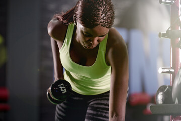 Black girl, weight or strength as fitness, health or wellness by training, exercise or workout. Fit, strong or athletic woman in gym, gear or muscle as power, performance or self care with dumbbell