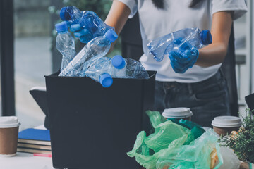 Close-up of female hands from a family collecting plastic waste and bottles from the ground. They...