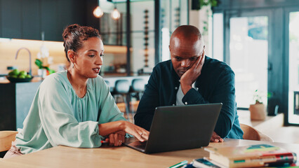 Budget, finance and laptop with couple in home together for insurance, investment or savings. Computer, planning or research with man and woman in dining room for financial or wealth management
