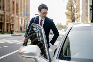 車とスーツを着たビジネスマン
