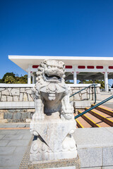 Obraz premium Stone Chinese Guardian Lion at Traditional Entrance on a Clear Day