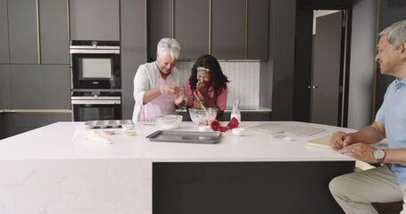 Three generations baking together in modern kitchen, sharing laughter and joy
