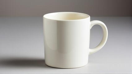 Obraz premium A Solitary Creamy White Mug Stands Ready, Begging to be Filled with Warmth on a Softly Lit Surface.