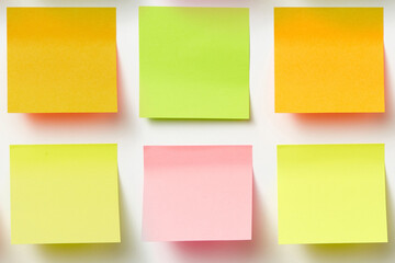 lots of blank square paper multicolored sticky notes isolated on white, close up