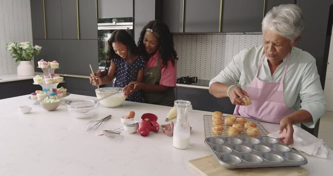 Three generations baking together in modern kitchen, sharing joy and laughter