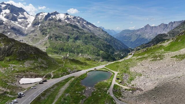 Flight over top of mountain pass Susten Pass with serpentine road towards lake Steinsee and mountain panorama in the Swiss Alps, Switzerland