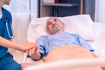 Obraz premium scene of elderly male patient looking at a nurse in uniform who supporting,holding hand and encourage him