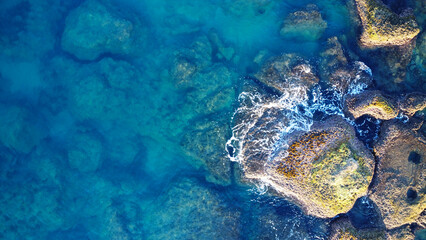 Aerial View of Rocky Shoreline and Clear Turquoise Water