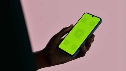 Black African-American young male using smartphone with a blank green screen. Mobile app video...