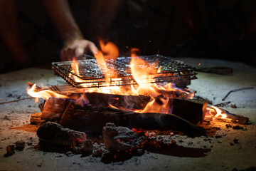 Meat in a grill grate being grilled on  an open fire in Botswana Africa in the night 