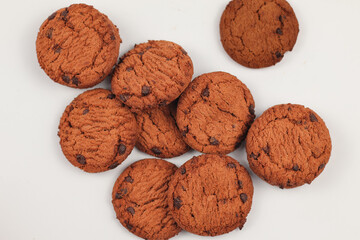 Isolated clipping path of die cut dark chocolate chip cookies piece set stack and crumbs on white background of closeup tasty bakery organic homemade 