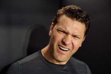 Studio shot of man with frustrated facial expression looking at camera.