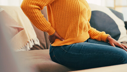 Hands, relax and woman with back pain at house for joint inflammation, spine accident and relief....