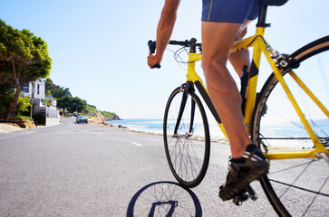 Obraz premium Cycling, legs and person on bicycle travel, morning trip or journey for outdoor fitness, exercise or workout. Wellness, sports and athlete on cardio bike, active hobby or training for triathlon race