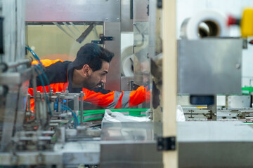 Canned food manufacturing factory industry business entrepreneur. Male mechanical engineer inspection, maintenance and repairing automated conveyor belt system machine in production line plant room.