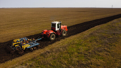 Obraz premium Aerial View of a Tractor Plowing a Field
