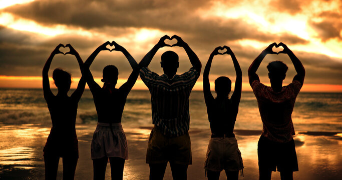 Friends, heart hands and people by sunset, beach and back with connection for love with care by sea. Group, together and community for symbol, sign and support with kindness on vacation by ocean