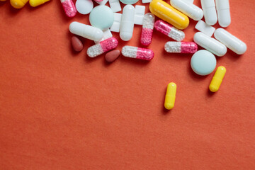 A variety of pills in the background: bright medicines and their packaging, representing the pharmaceutical industry and human health.