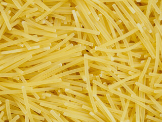 Close-up of small, thin vermicelli filini pasta. Delicate strands create a fine, textured food background.