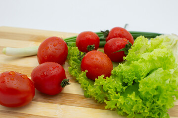 assorted fresh vegetables including tomatoes peppers and leafy greens healthy food variety white background