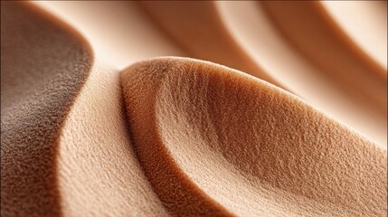 A close-up view of rippled sand dunes, displaying a warm, textured pattern.