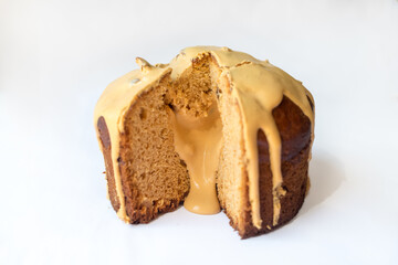 Delicious Easter Kulich cake with milk filling and raisins and candied fruit isolated on white...