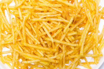 Plato de patatas fritas tipo paja con fondo blanco