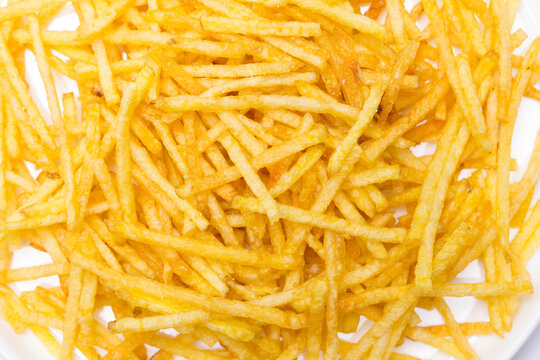 Plato de patatas fritas tipo paja con fondo blanco
