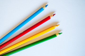 colored pencils laud out on a blank white sheet of paper