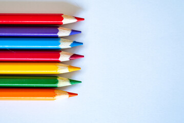colored pencils laud out on a blank white sheet of paper
