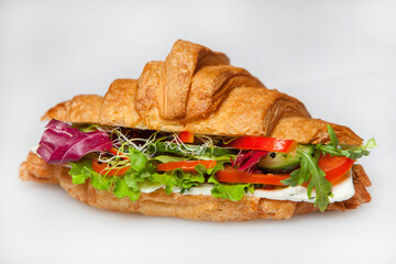 Croissant sandwiche with salmon and green parsley. Croissants with red fish on wooden cutting board. Healthy breakfast. Appetizer. Starter meal