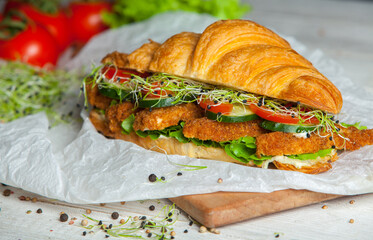 Croissant sandwiche with salmon and green parsley. Croissants with red fish on wooden cutting...