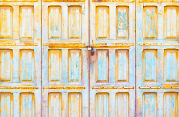 Locked old wooden garage doors with peeling paint