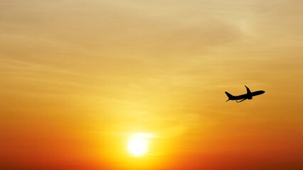 Airplane Silhouette at Sunset: A silhouette of a commercial airplane soaring high above the clouds at sunset, with a fiery orange sky and a blazing sun in the background.