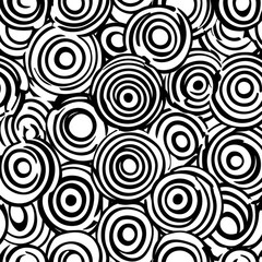 Abstract black and white concentric circles pattern.  A seamless design of overlapping circles with varying thicknesses and textures