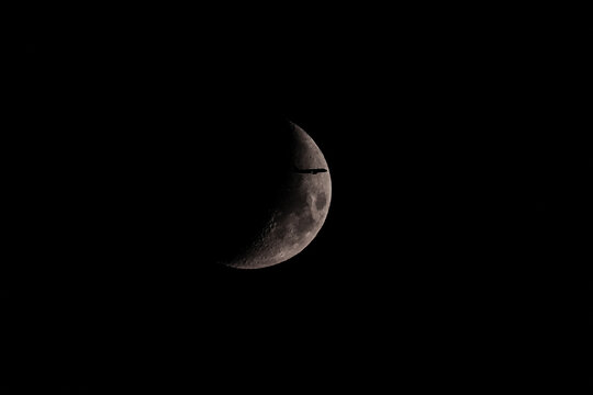 Silhouette of an Airplane in front of Moon
