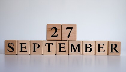 Minimalist photo of wooden blocks with date 27 September. Day and month, calendar on white background