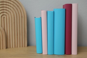 Many colorful books on wooden table indoors, closeup